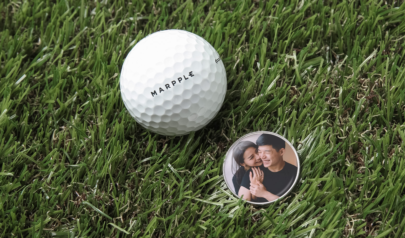 잔디 위에 놓인 커플 사진 커스텀 볼마커 - 마플 골프 볼마커 제작 예시