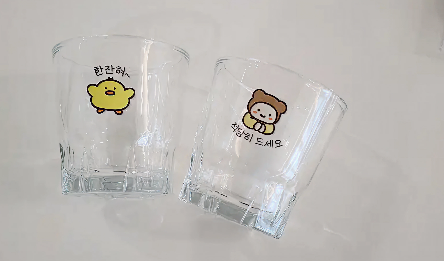 마플 소주잔 – 병아리·곰 캐릭터와 한글 문구를 풀컬러 수작업 인쇄해 제작한 소주잔 2개를 나란히 놓은 실구매 후기 사진