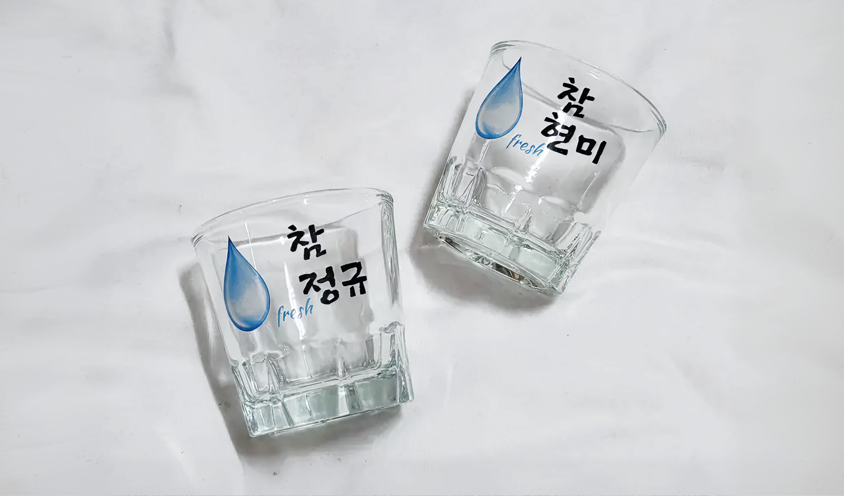 마플 소주잔 – 물방울 아이콘과 이름 문구를 풀컬러 수작업 인쇄해 제작한 커플 이름 소주잔 2개를 나란히 놓은 실구매 후기 사진