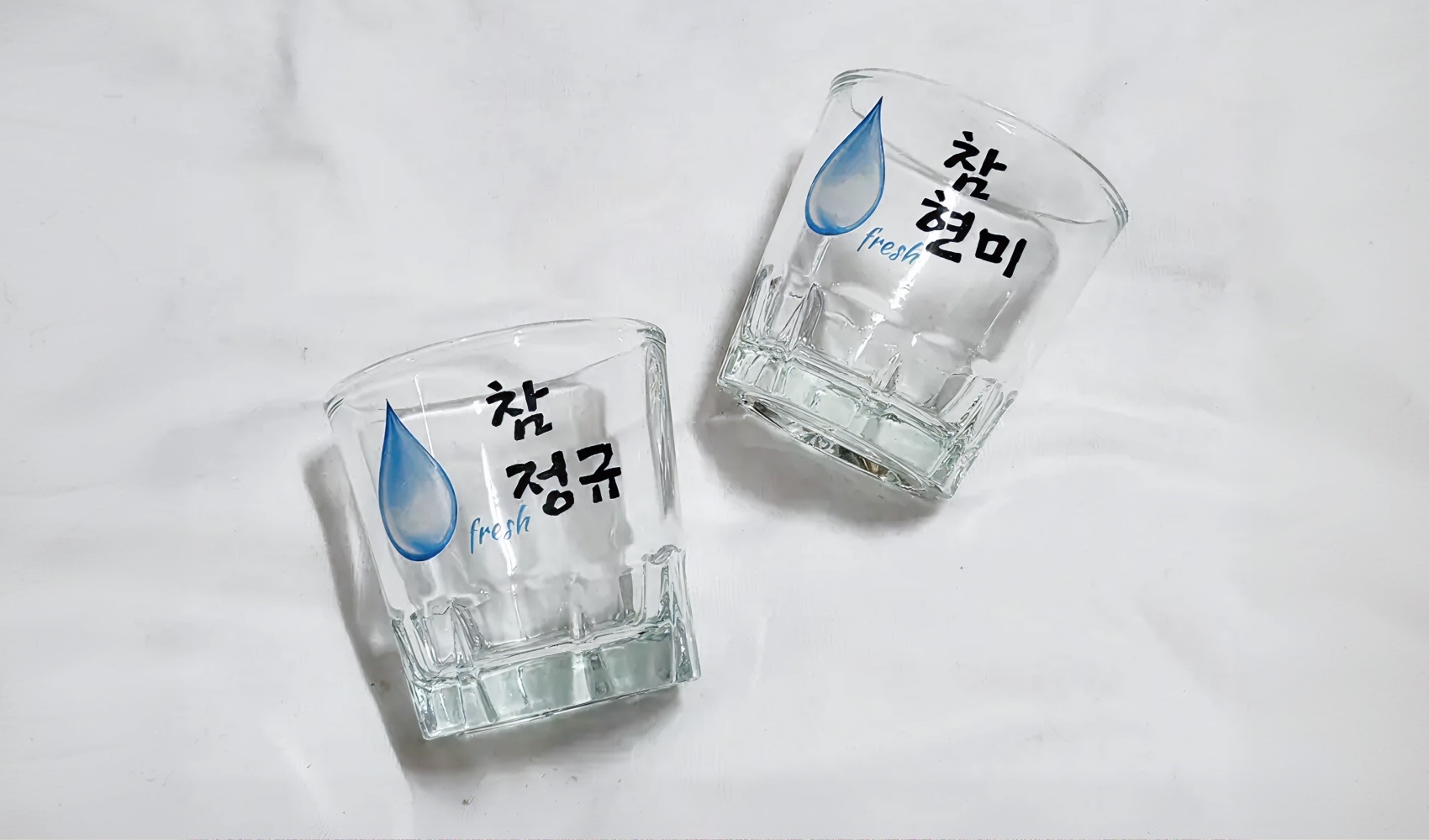 마플 소주잔 – 물방울 아이콘과 이름 문구를 풀컬러 수작업 인쇄해 제작한 커플 이름 소주잔 2개를 나란히 놓은 실구매 후기 사진