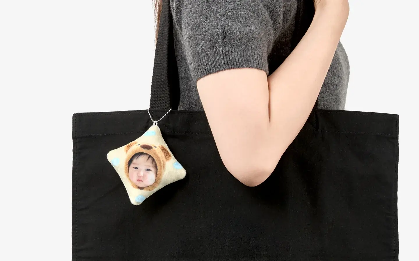 마플 정사각 쿠션 인형 키링 – 아기 사진을 인쇄한 폭신한 사각형 커스텀 키링을 검은색 가방에 달아 연출한 이미지