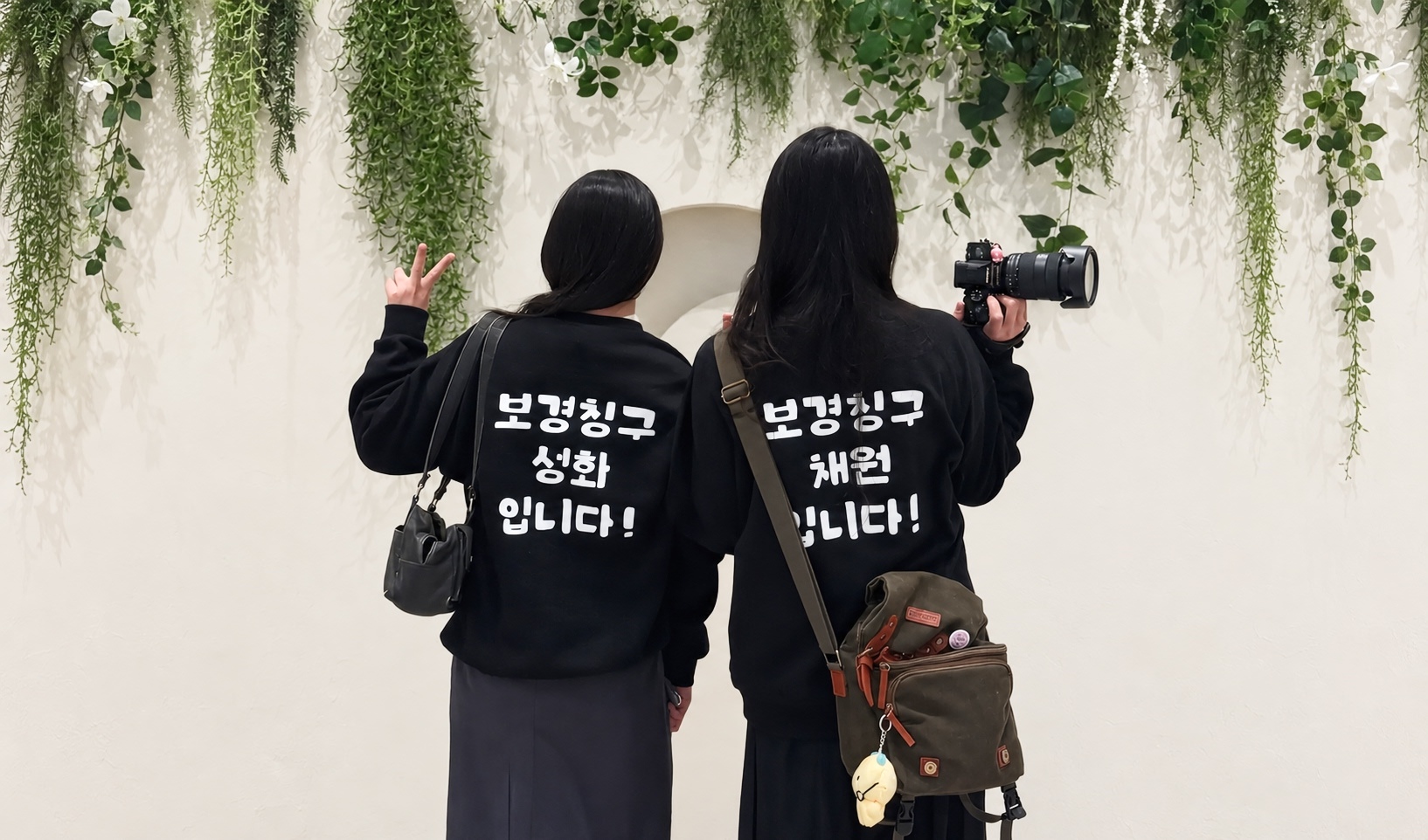 마플 단체 맨투맨 제작 – 이름과 문구를 흰색으로 프린팅한 블랙 맨투맨을 맞춰 입은 두 사람의 뒷모습 이미지