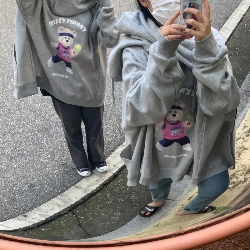 마플 친구 후드집업 제작 – 테니스 곰 캐릭터를 프린팅한 멜란지 그레이 후드집업을 맞춰 입고 거울 셀카를 찍는 두 사람 이미지