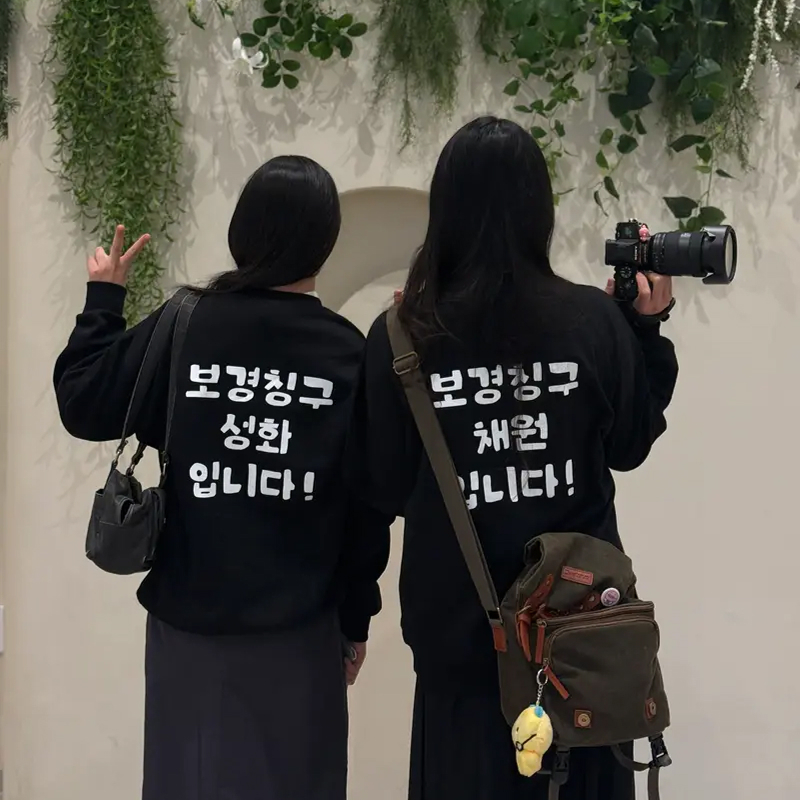 마플 친구 단체 맨투맨 – 이름과 소개 문구를 등판에 흰색으로 프린팅한 블랙 맨투맨을 맞춰 입은 두 사람의 뒷모습 이미지