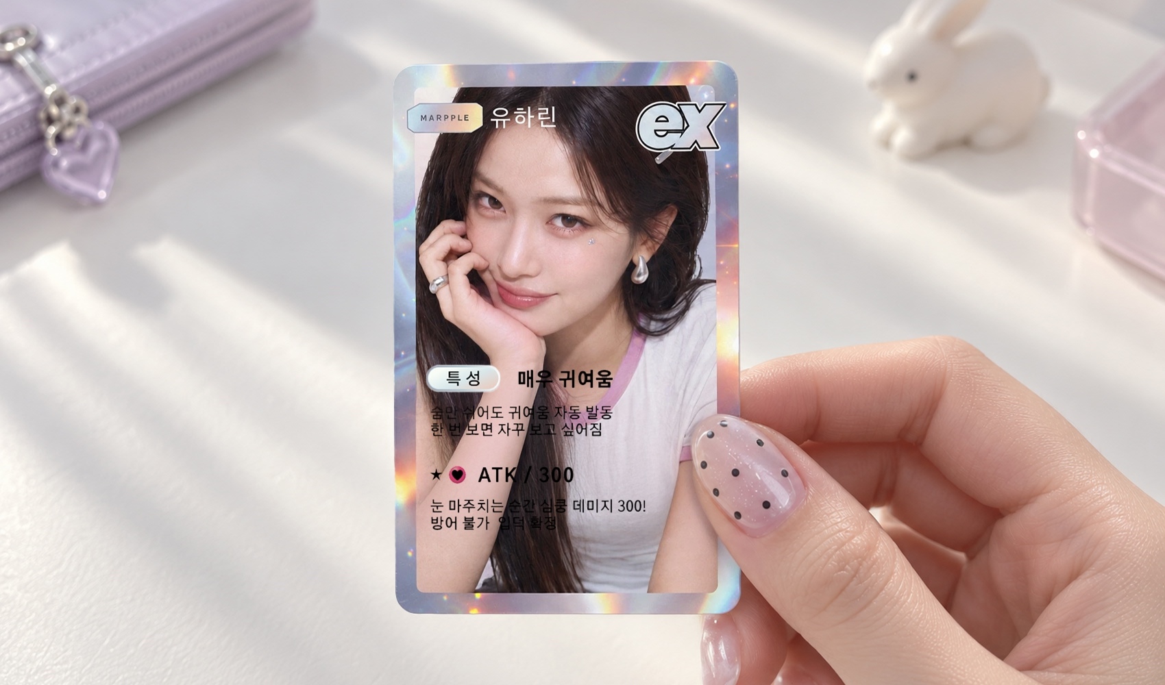 마플 커스텀 포토카드 – 여자 인물 사진과 이름, 특성, ATK 정보를 넣어 제작한 홀로그램 포토카드를 손에 들고 있는 이미지