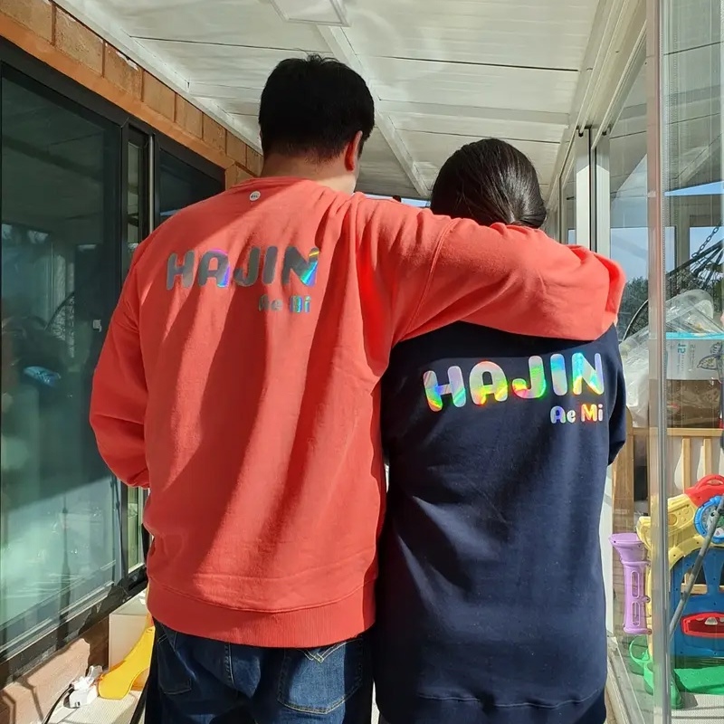 마플 커플 맨투맨 제작 – 홀로그램 레터링을 등판에 프린팅한 레드와 네이비 맨투맨을 맞춰 입은 커플의 뒷모습 이미지